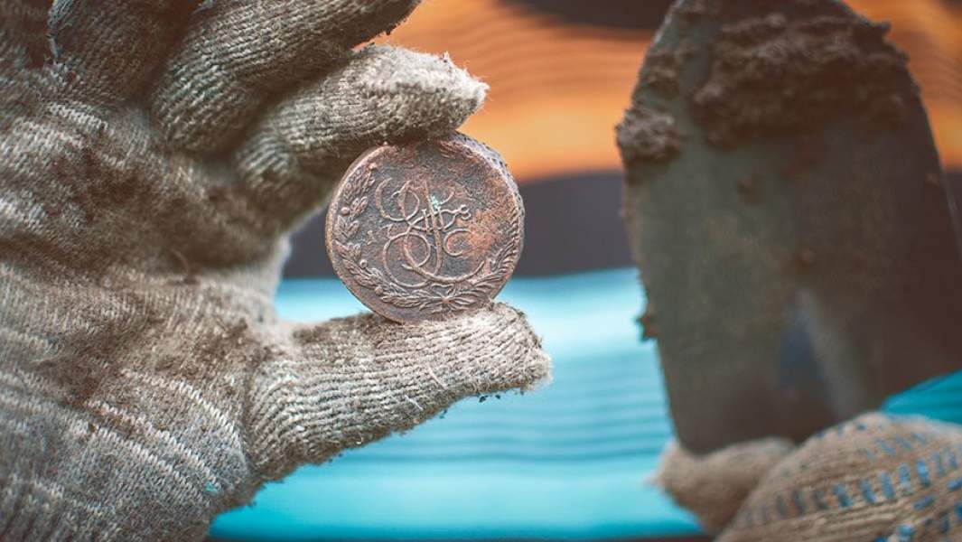 Монета в руках кладоискателя