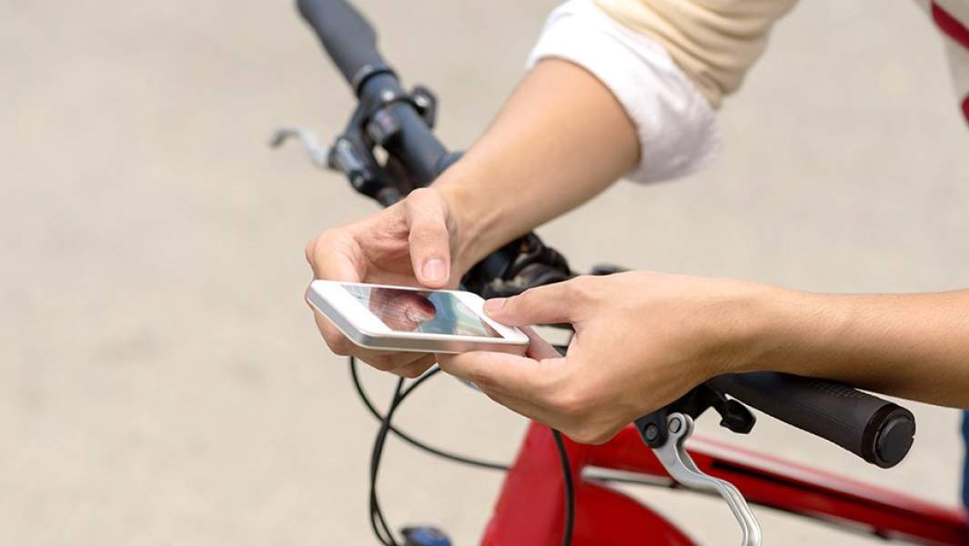 велосипед - парень смотрит в смартфон 