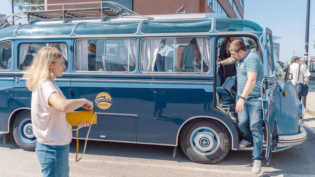 Пассажир выходит из ретро-автобуса 