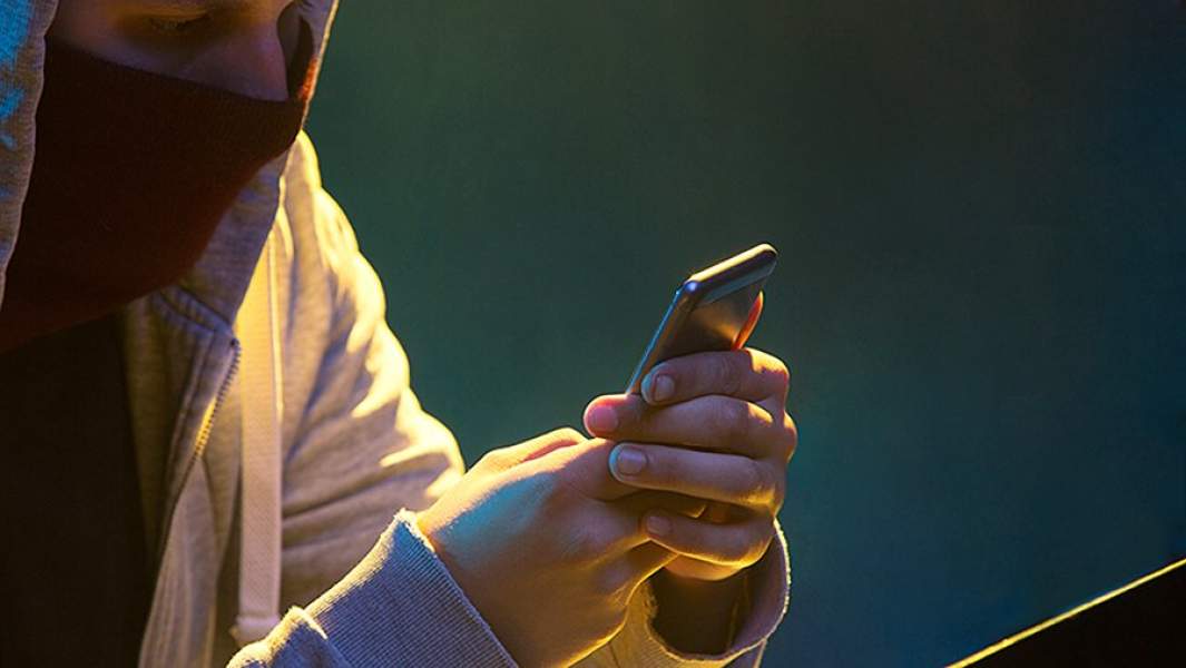 человек в капюшоне общается по телефону