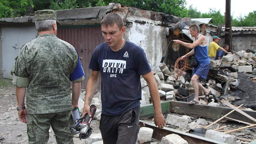 Жители, сотрудники МЧС ДНР и представители ДНР из Совместного центра по контролю и координации режима прекращения огня (СЦКК) устраняют последствия разрушений, полученные в результате артиллерийского обстрела