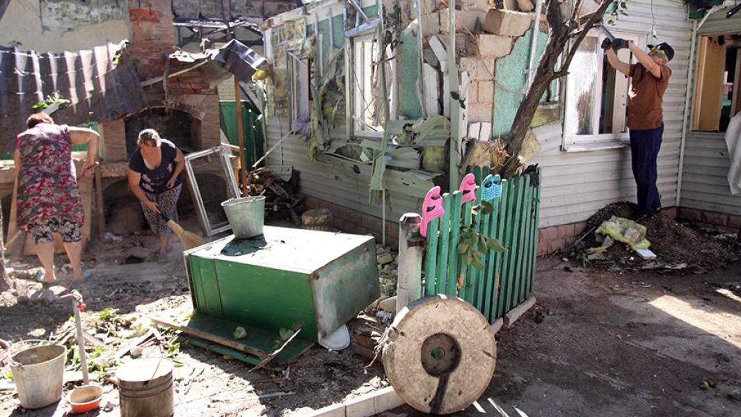 Жители на территории своего дома, который был разрушен в результате ночного обстрела ВСУ