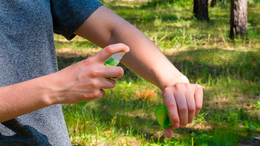 Девушка наносит спрей от комаров