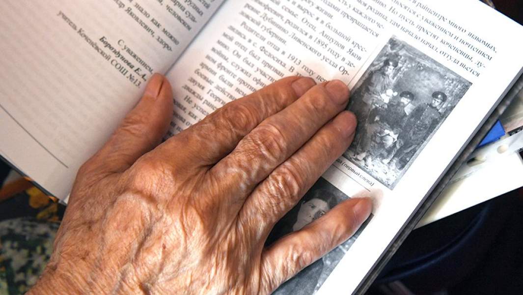рука пенсионера на старой книге 