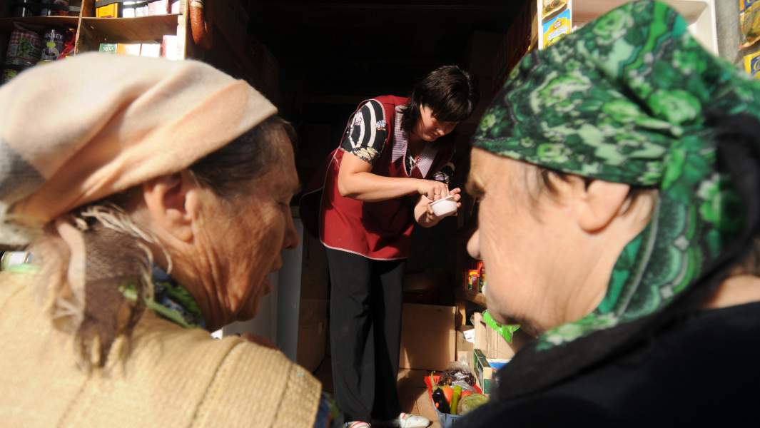 женщины покупают у прилавка продукты