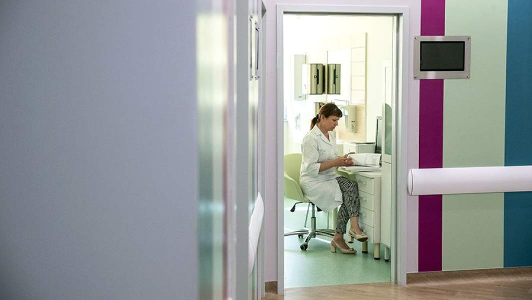 Женщина-врач в кабинете работает с документами