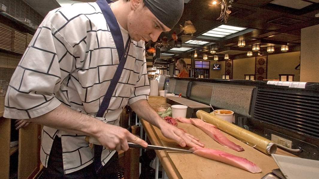 Повар ресторана готовит рыбу