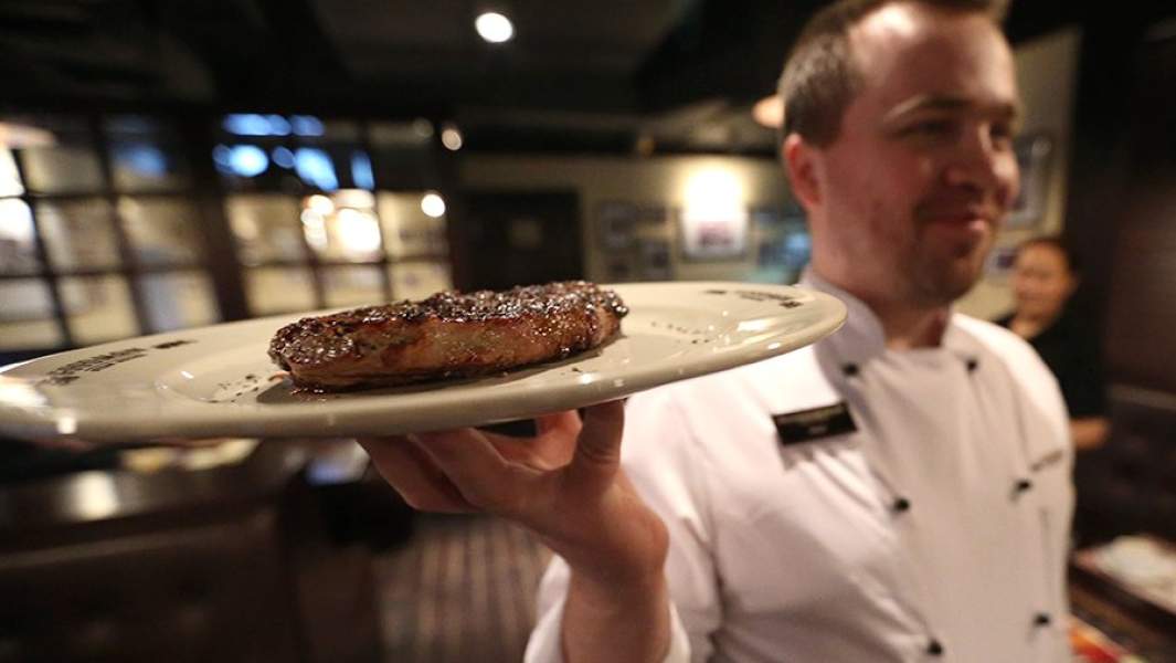 Официант подает блюдо