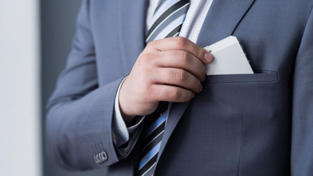 смартфон в кармане у бизнесмена