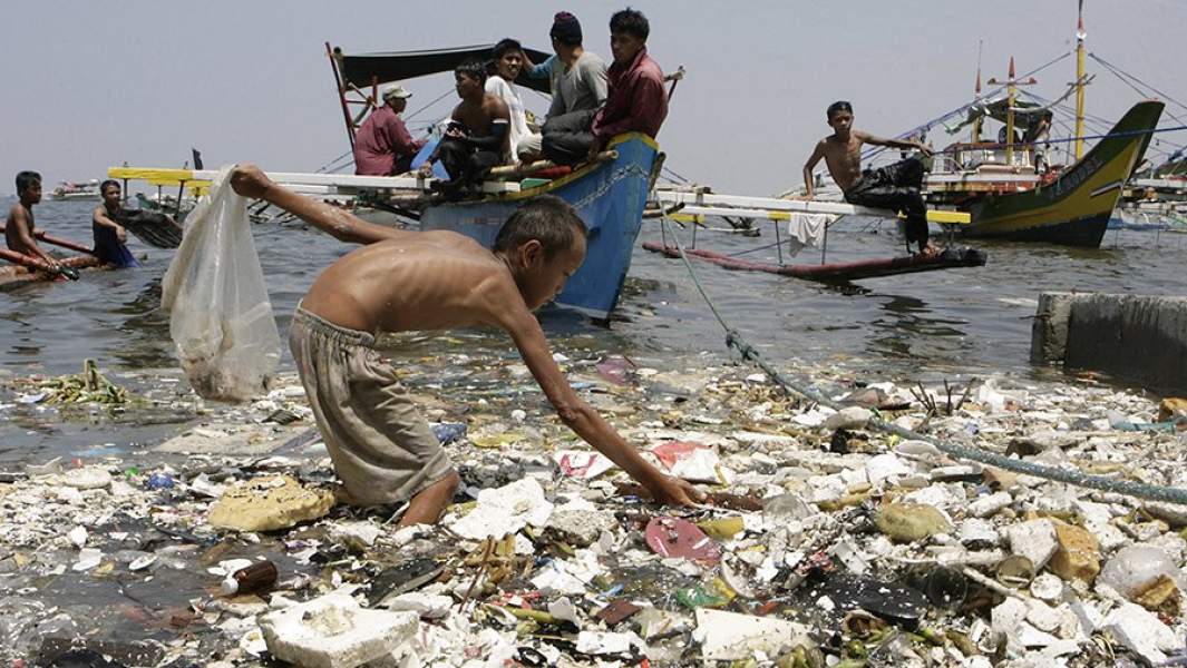 Мальчик собирает пластиковый мусор на побережье Филиппин