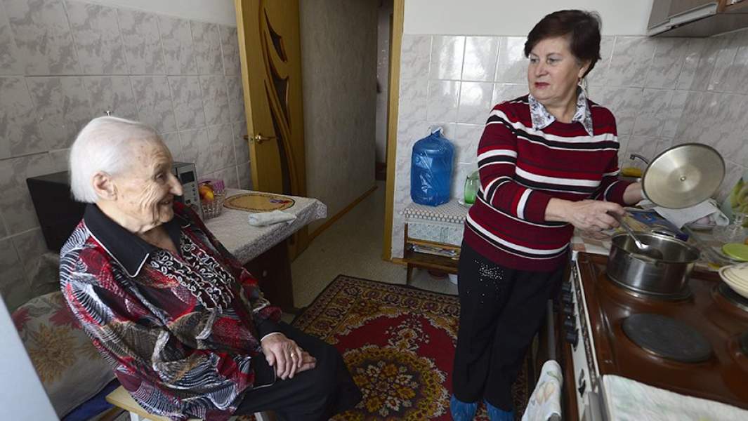 Женщина готовит обед пенсионеру