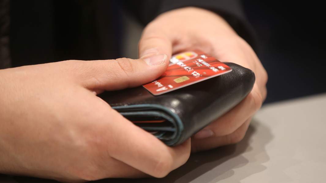 в руках кредитка и кошелек