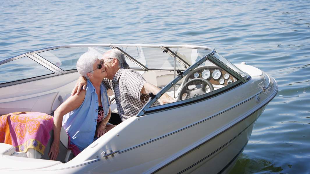 пожилая пара едут на катере