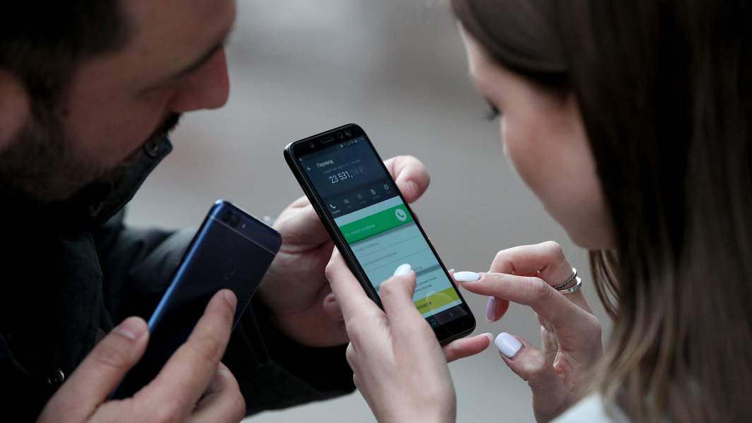 девушка изучает мобильное приложение банка  