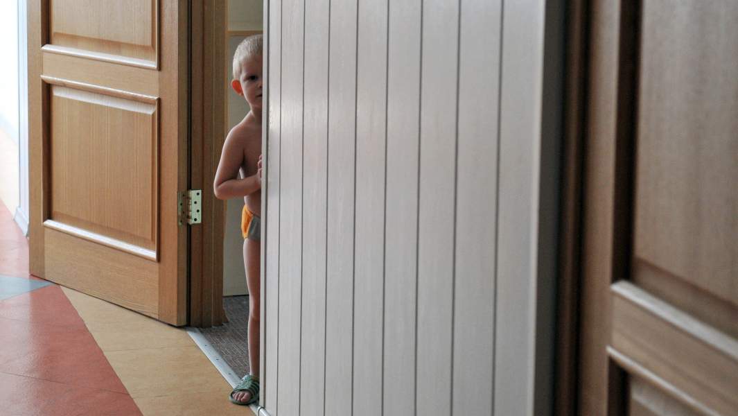 ребенок выглядывает из-за угла