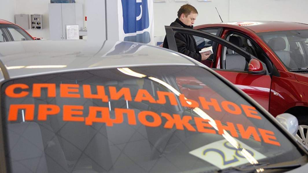 Посетитель осматривает автомобиль в автосалоне