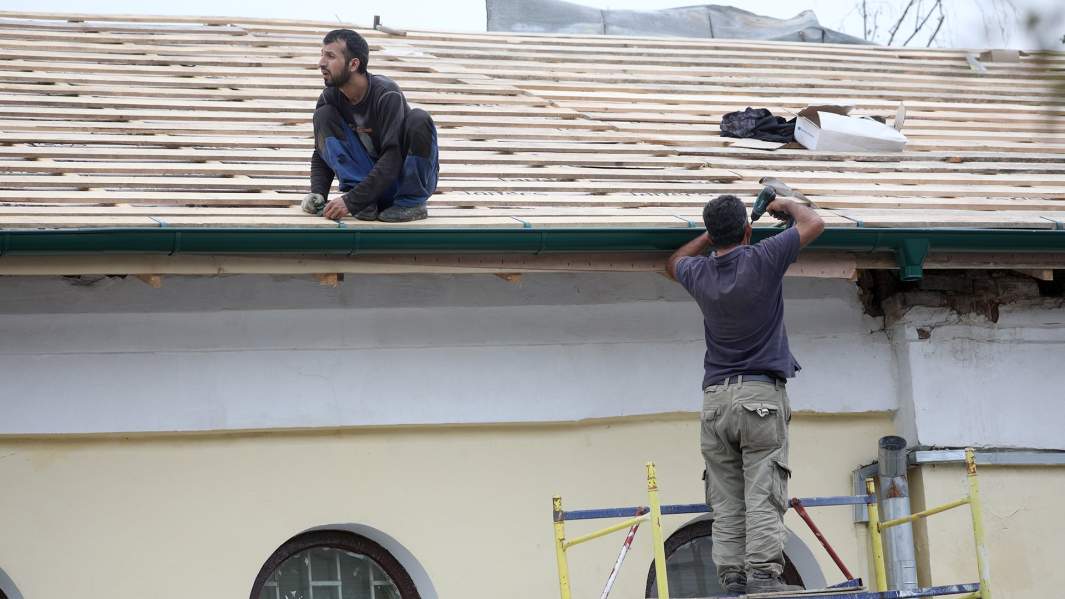 рабочие строят дом 