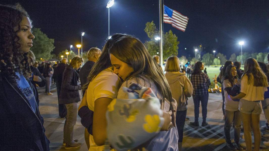 Скорбящие по жертвам стрельбы в Санта-Кларите