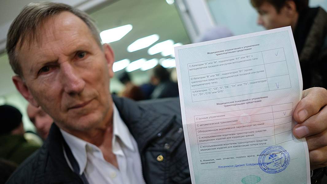Мужчина демонстрирует медицинское заключение после прохождения транспортной комиссии в медицинском центре