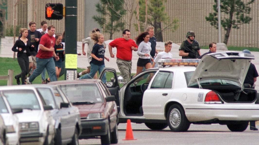Ученики и персонал старшей школы «Колумбайн» выбегают из здания