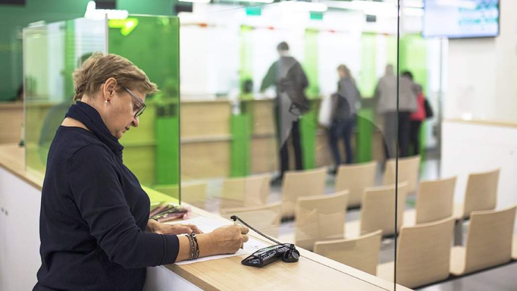 Женщина подписывает документ