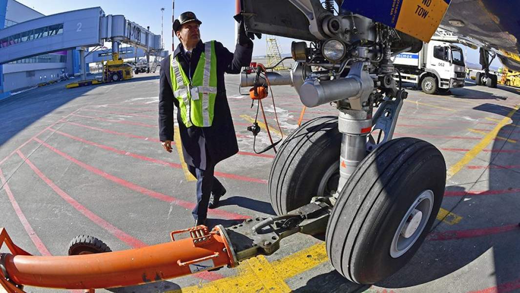 Сотрудник аэропорта проверяет самолет