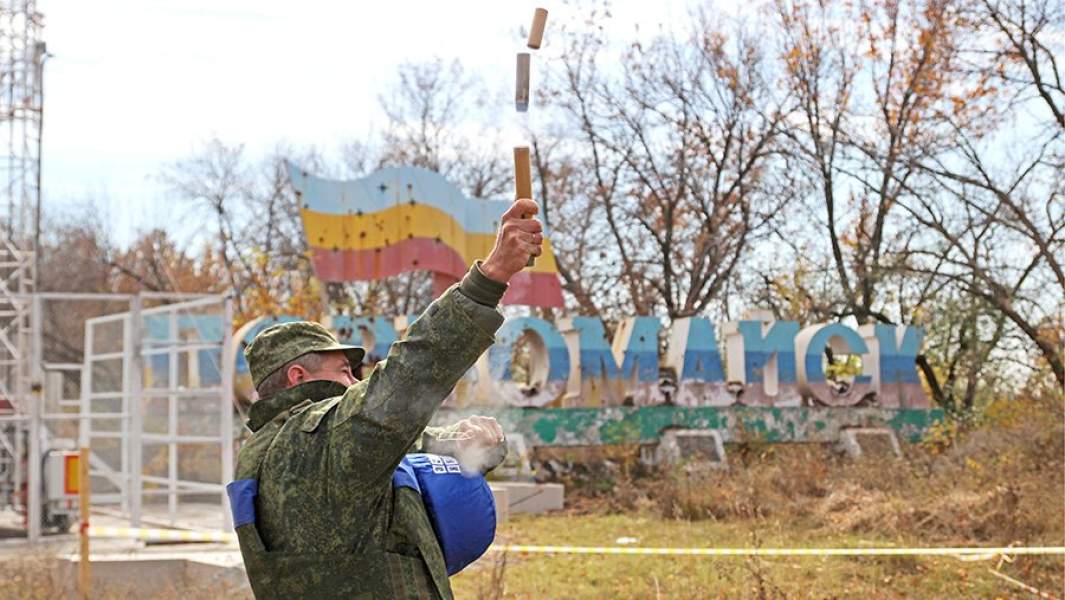 Представитель Совместного центра по контролю и координации режима прекращения огня (СЦКК) запускает сигнальную ракету для начала разведения сил сторон конфликта в Донбассе в районе села Золотое