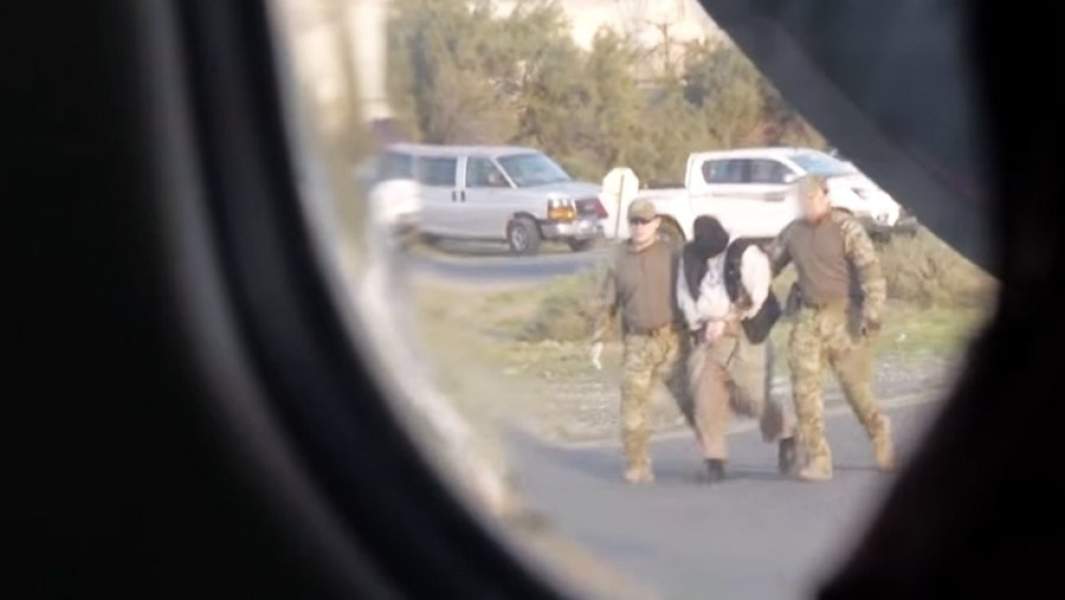 Полиция конвоирует подозреваемого в терроризме 