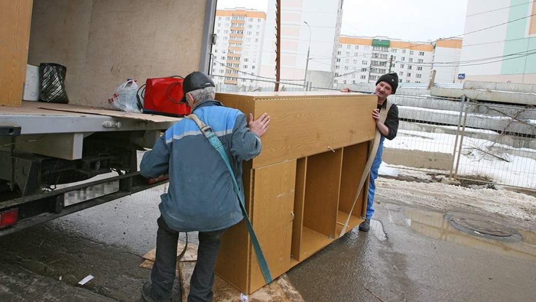 Грузчики поднимают пианино