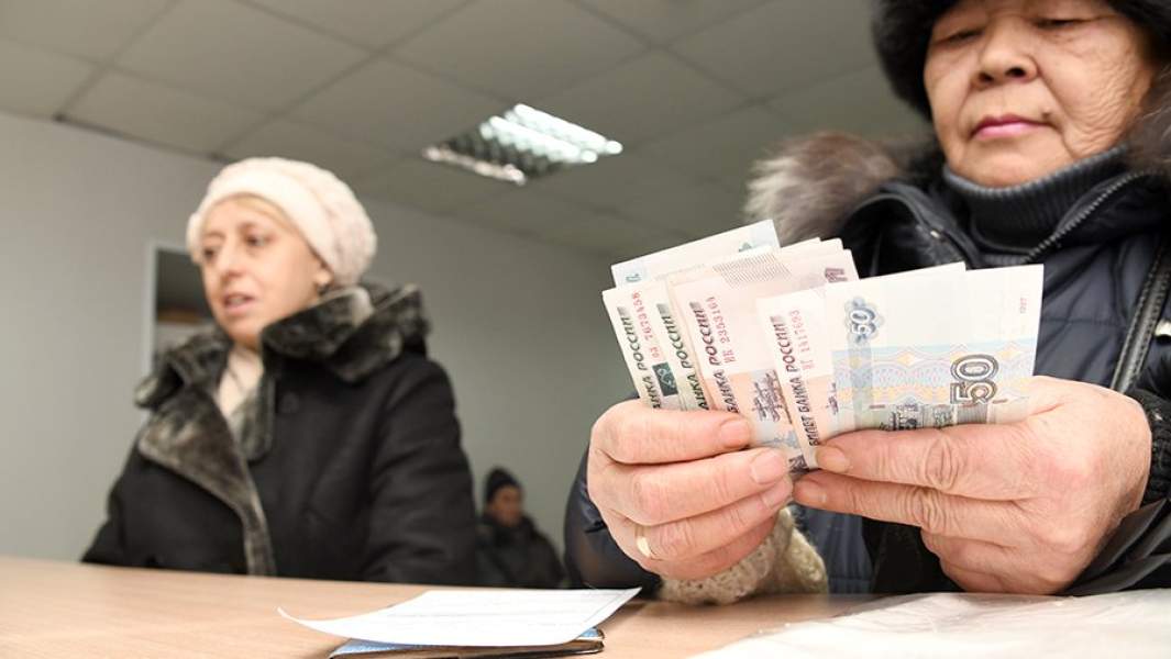 Женщина пересчитывает полученную пенсию на почтамте в Чите