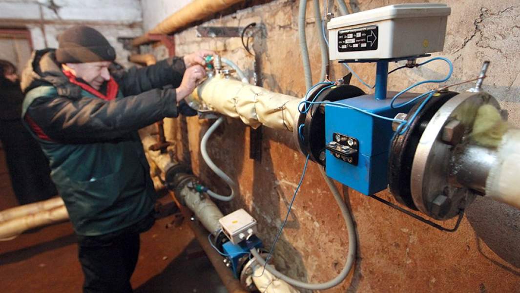 Сотрудник коммунальных служб проверяет систему отопления и горячего водоснабжения в подвале одного из жилых домов