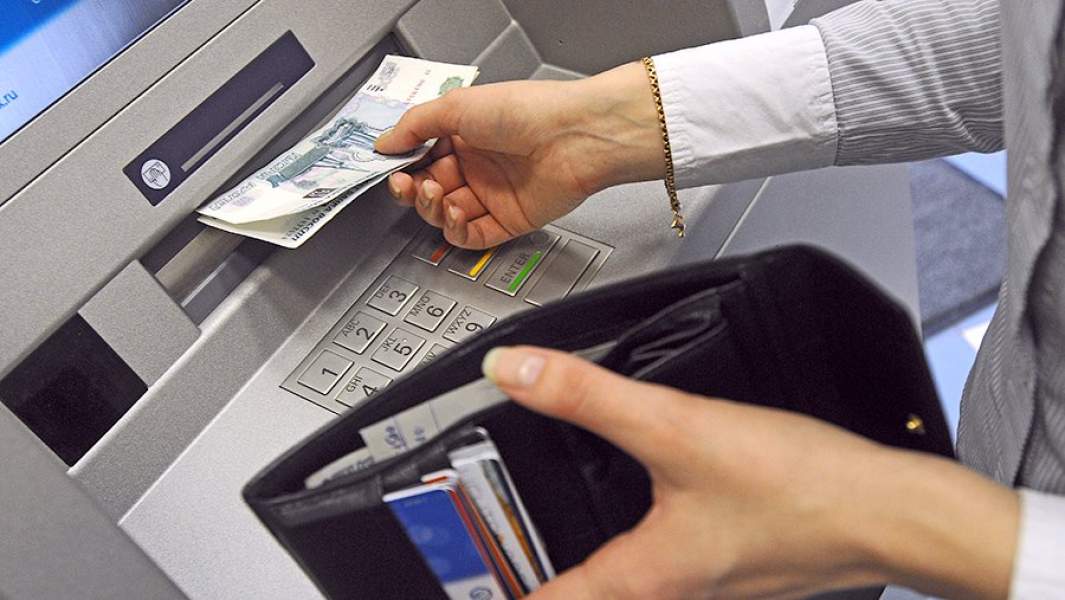 Девушка снимает деньги в одном из банкоматов Санкт-Петербурга