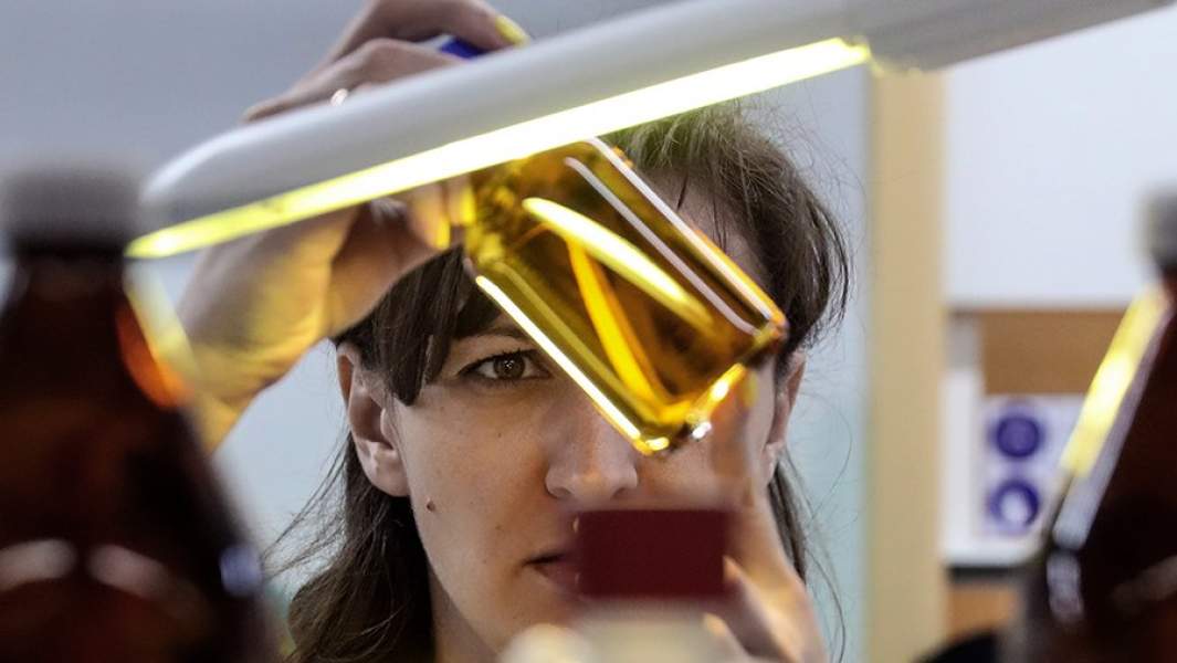 Проверка прозрачности пива в мутномере в лаборатории завода 