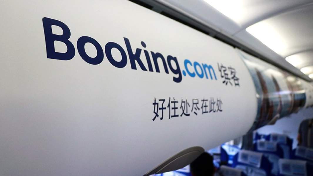 Логотип Booking.com на полке в салоне самолета