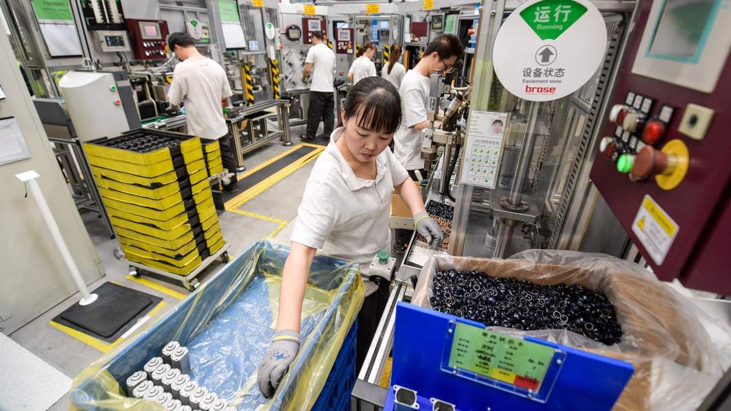 Рабочие китайского завода собирают автомобильные детали