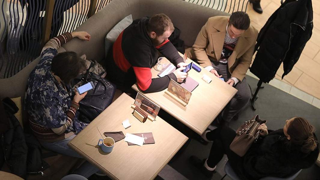 Люди со смартфонами в кафе