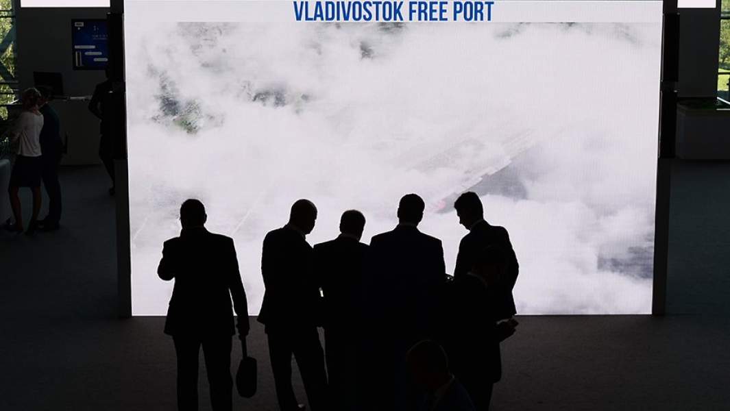 Бизнесмены около стенда свободного порта Владивосток