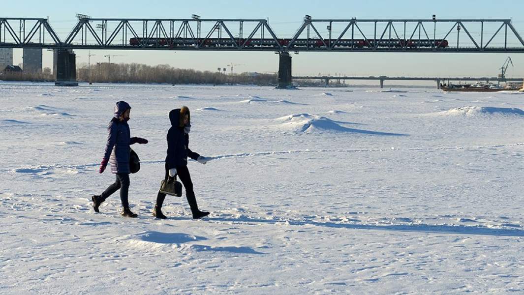 Горожане гуляют по замерзшей реке Обь у железнодорожного моста в Новосибирске