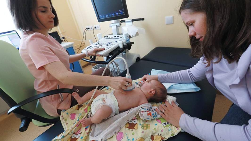 Мама с ребенком в кабинете УЗИ детской поликлиники