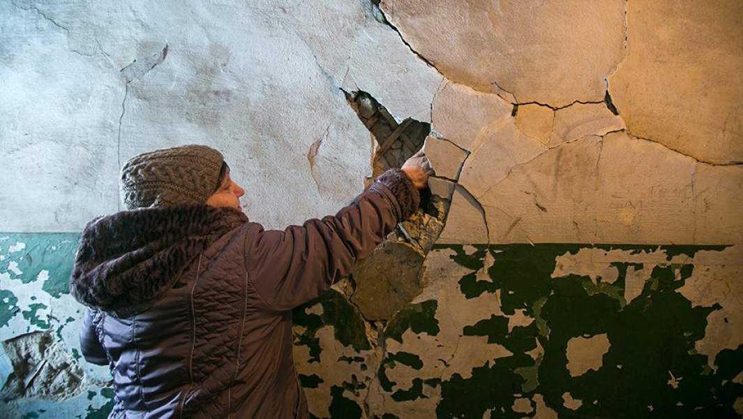 Женщина в подъезде ветхого многоквартирного дома