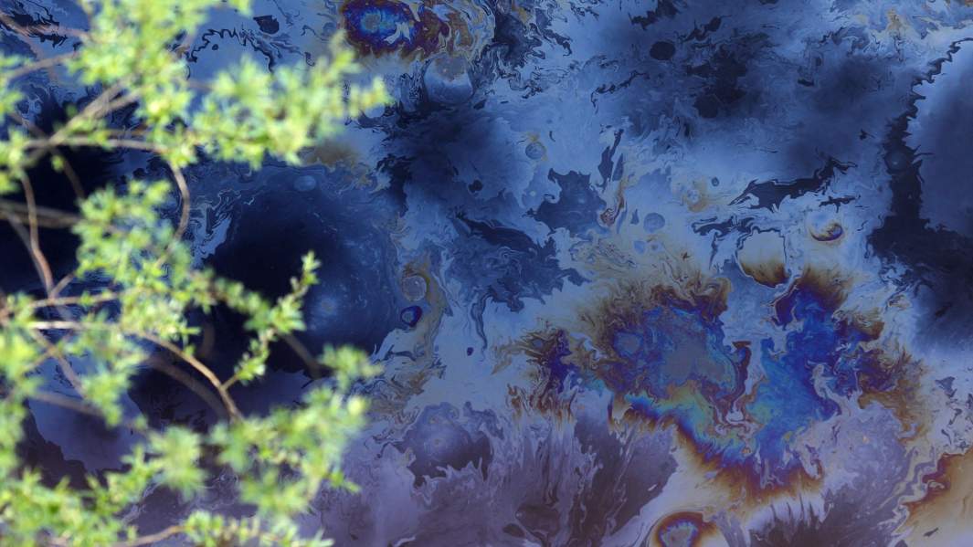 Нефтяное пятно на реке в результате утечки нефти из нефтепровода