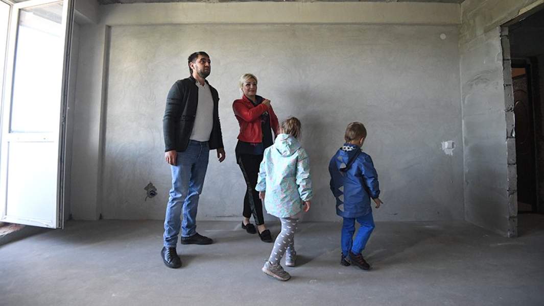 Семья осматривает квартиру нового дома