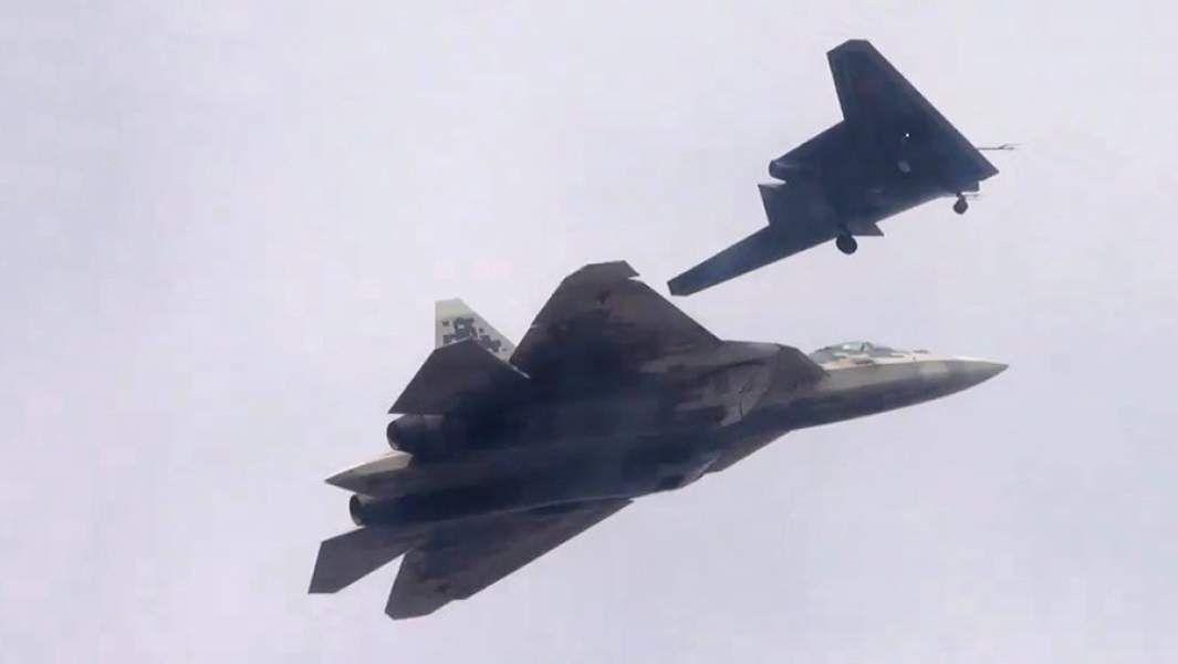 Ударный беспилотник «Охотник» (на втором плане) во время первого совместного полета с Су-57 на одном из испытательных аэродромов Минобороны России