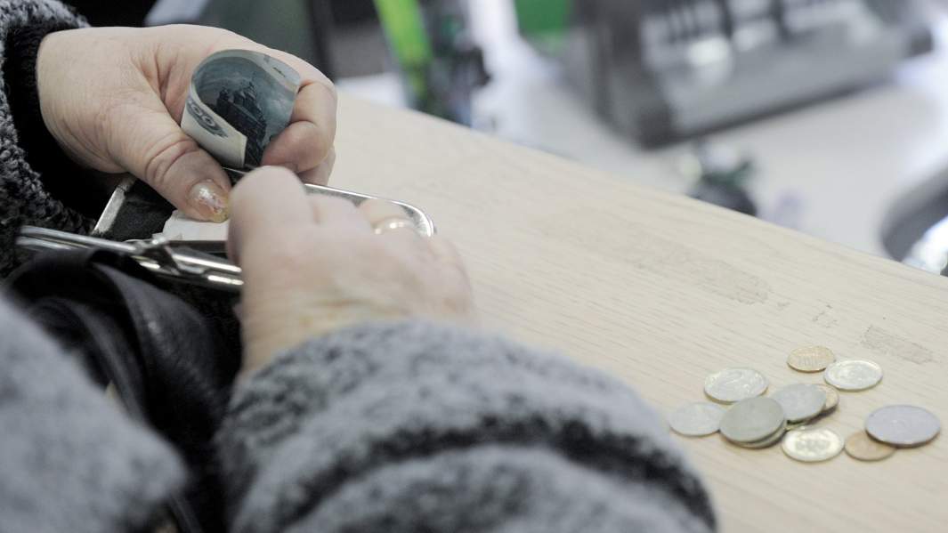 Женщина в кассе с деньгами в руках