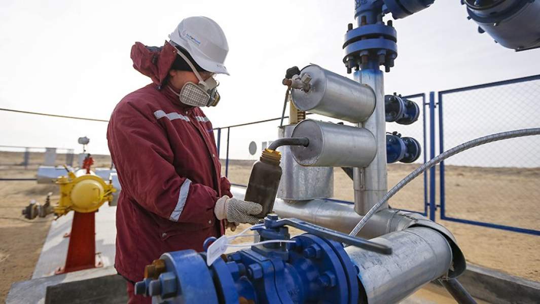 Рабочий берет пробу нефти на месторождении Кызылорда в Казахстане