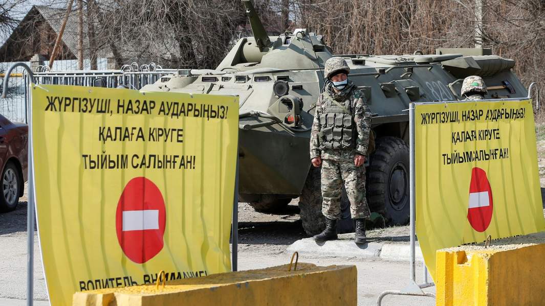 Казахский военнослужащий в защитной маске на контрольно-пропускном пункте на окраине Алма-Аты