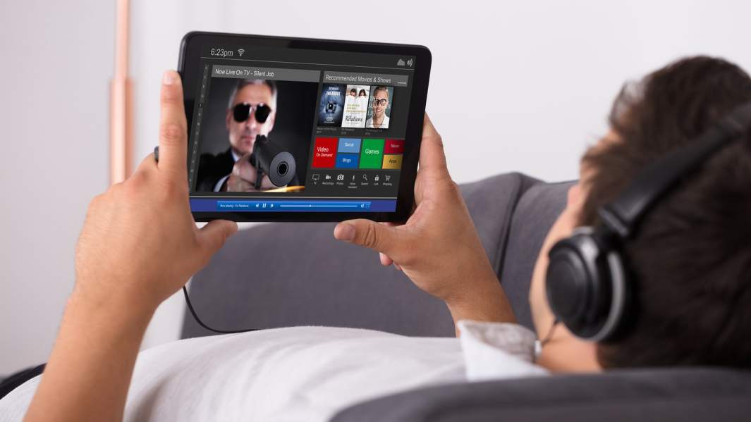 парень смотрит фильм на планшете