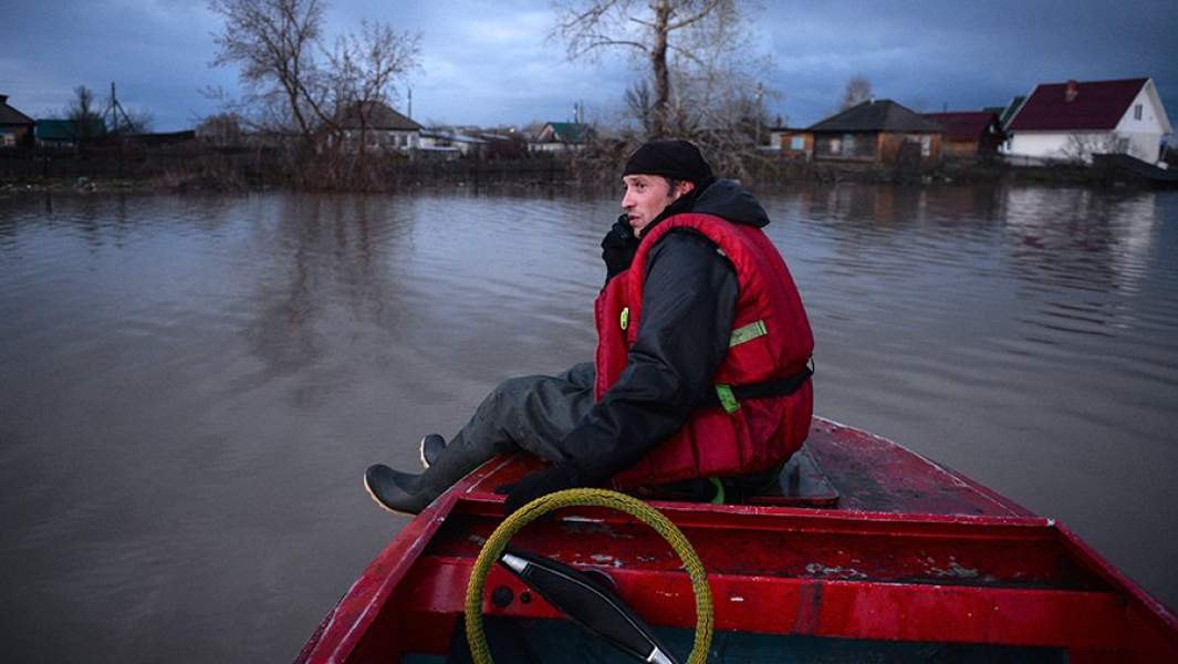 Спасатель на лодке во время работ в затопленной части одного из городов Алтайского края
