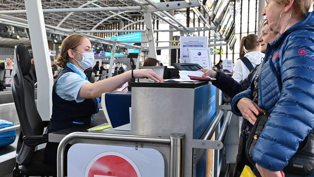 Сотрудница аэропорта производит регистрацию пассажиров и багажа на рейс в Международном аэропорту Сочи