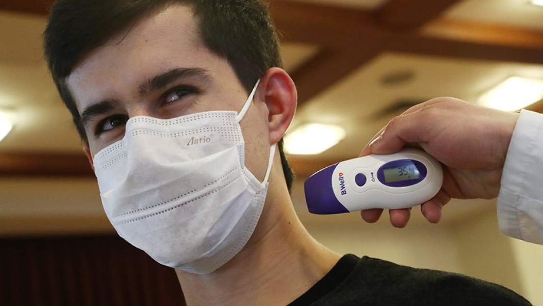 Мужчине измеряют температуру в рамках мер безопасности и профилактики  коронавируса